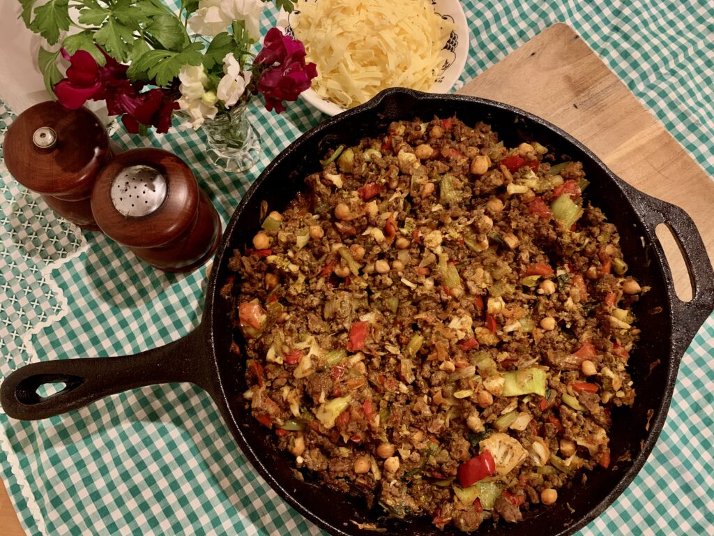Nutritious, healthy savoury mince in cast iron fry pan skillet with vintage table cloth.  