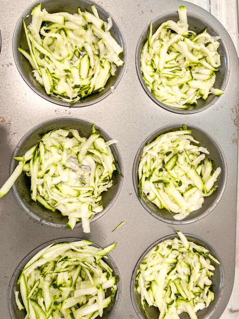 grated zucchini in muffin tray