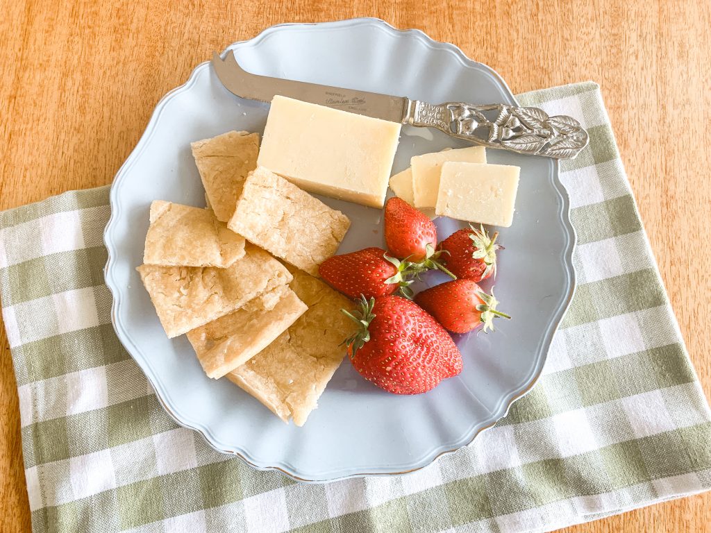 Simple and Cripsy sourdough crackers on a vintage Australia blue plate with a gum leaf cheese knife and home grown strawberries and cheese